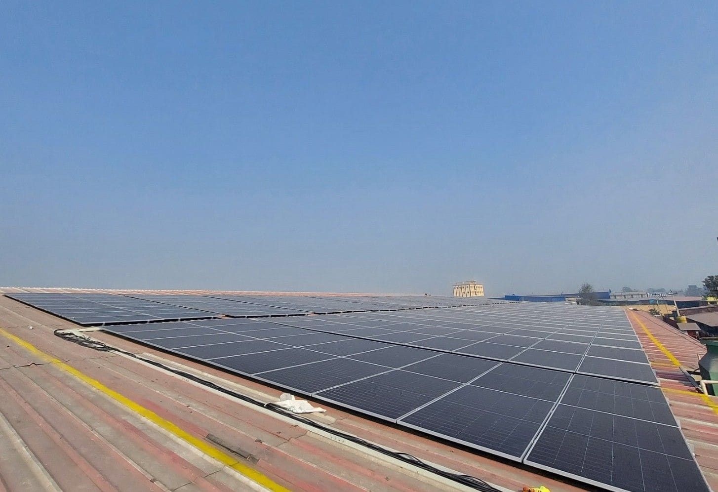 Close-up of rooftop solar panel installation at a Jayshree Group factory